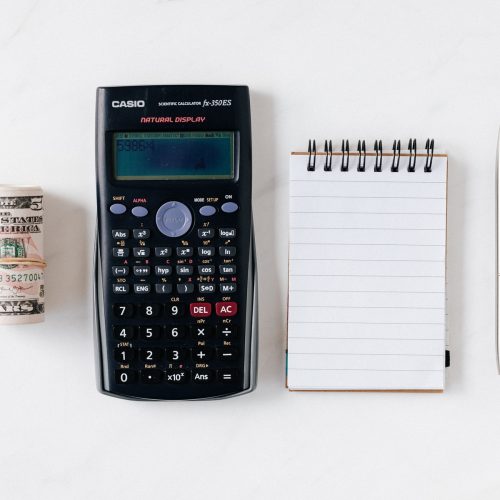 composition-of-calculator-with-paper-money-and-notebook-with-4386341